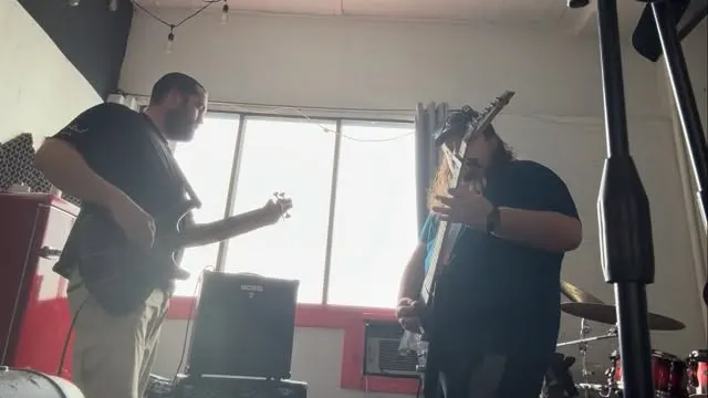 Band rehearsing beside a studio window at Marsonic
