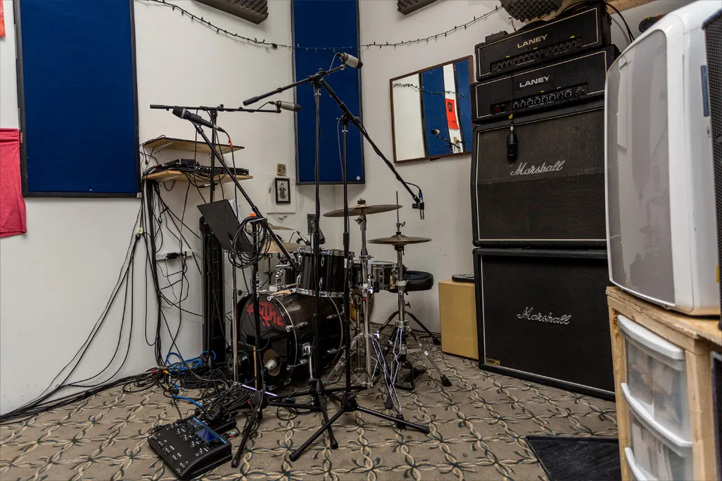 Marsonic rehearsal room with drums, microphones, amps, and cables set up